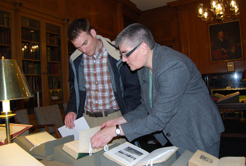 Taraba, at right, shows Seth Redfield, assistant professor of astronomy, a first edition copy of Charles Darwin's On the Origin of Species dated 1859.