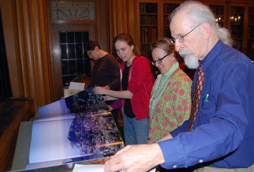 From right, Erhard Konderding, documents librarian; Michaelle Biddle, head of preservation services; and Eve Mayberger '10 unfold a photo inside the 60-pound book, Earth, by David Bellamy.  Beth Emery, head coach of women's crew, is pictured in the back. (Photos by Olivia Bartlett) 