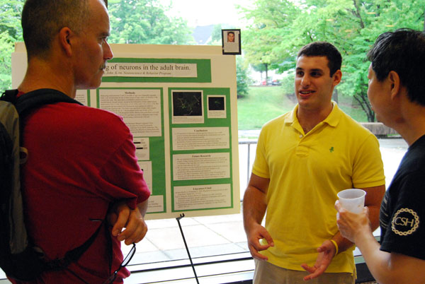 At left, Stephen Devoto, associate professor of biology, associate professor of neuroscience and behavior, listens to Hughes Fellow Mike LeVine '11, center, speak about his research titled "Fate Mapping of Neurons in the Adult Brain." LeVine's advisors were John Kirn, chair and professor of neuroscience and behavior, director of graduate studies, professor of biology, and Stanley Lin, lecturer in biology, who is pictured at right. 