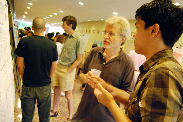 Hughes Fellow Juan Carlo Francisco '11 speaks to Michael Weir, director of the Hughes Program in the Life Sciences, professor of biology, about his project "Comparative Analysis of Ecotype Demarcation Algorithms" during the 2009 Summer Undergraduate Research Poster Presentations July 31 in Exley Science Center. Francisco's advisors were Danny Krizanc, professor of computer science, and Fred Cohan, professor of biology.
