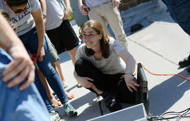 Meredith Hughes, assistant professor of astronomy, works with students on a small radio telescope, located on the roof of the Van Vleck Observatory. 