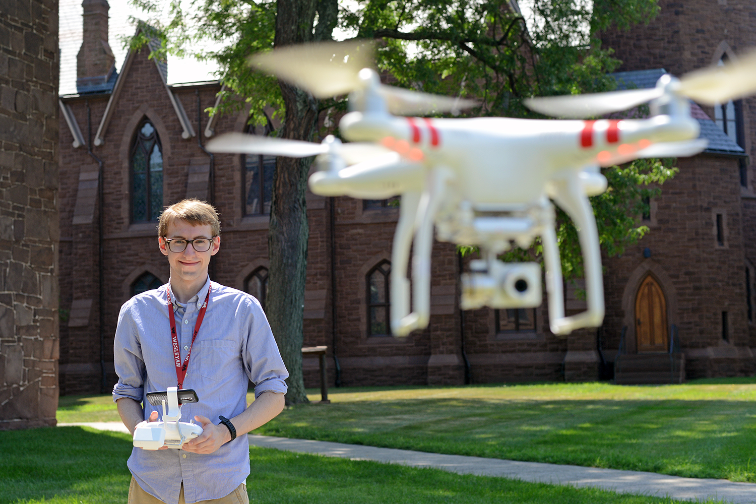 David Schwartz '17, founder and president of the Wesleyan Radio Control/ Drone Club, flies a drone behind South College July 28. He's also on Wesleyan's ski team, rock climbing team and sailing team. (Photo by Olivia Drake)
