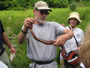 Hammerson shows a snake to students, including Nicole Lee, pictured in background.