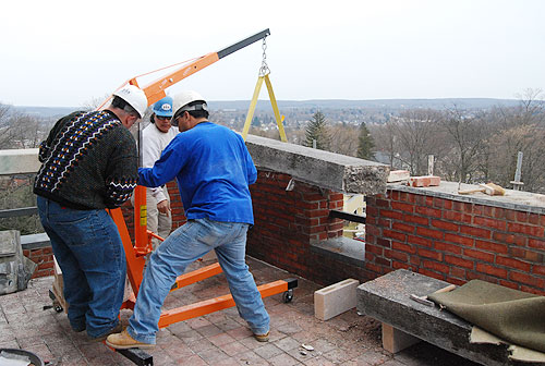 Contractors use a davit to hoise a limestone coping cap on the fourth-floor terrace. The fourth floor will house The Shapiro Creative Writing Center and a Certificate Program in Creative Writing. A meeting room will overlook the terrace. 
