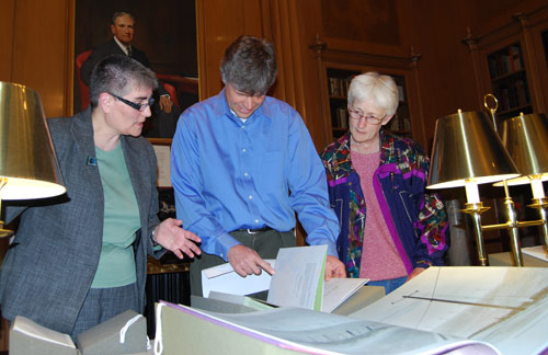 At left, Suzy Taraba, university archivist and head of Special Collections, speaks to Phil Resor, assistant professor of earth and enviornmental sciences, and Suzanne O'Connell, chair and professor of earth and environmental sciences, director of the Service Learning Center, during the Special Collections and Archives Earth Day Open House April 22. Taraba is explaining printer and publisher Robin Price's "43." Paper maps from locations along the 43rd parallels are bound in an accordion that structurally supports the main text, which is printed on graph paper and joined together as an accordion. 