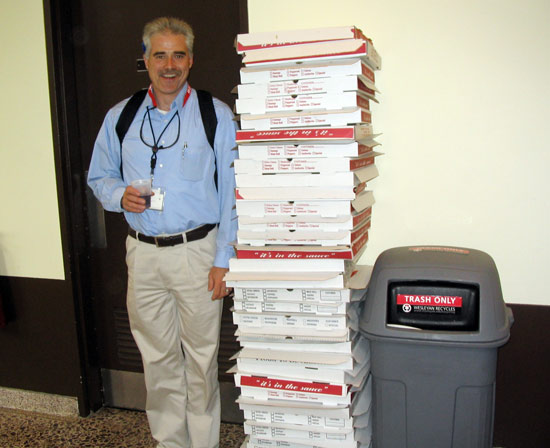 Bill Nelligan, director of environmental halth, safety and sustainability, stands by empty pizza boxes from the party. Nelligan taught the fellows about safety issues. (Photos by Laurel Appel)