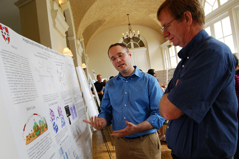 Chemistry graduate student Daniel Czyzyk, center, explains his research titled "Heptosyltransferase I and its Role in Biofilm Formation." Czyzyk's advisor is Erika Taylor, assistant professor of chemistry. 