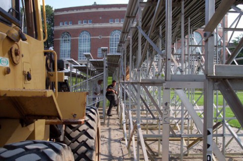 The bleacher segments are stored near the tennis courts on Lawn Avenue and trucked to campus. A forklift is used to arrange the bleacher segments.