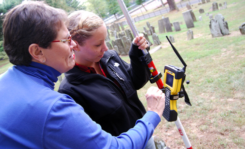 Elizabeth Milroy, director of the Art History Program and professor of art history and American studies, and Anne Calder '11 use a scanning tool to survey grave markers in the Washington/Vine Street Cemetery Oct. 2. 