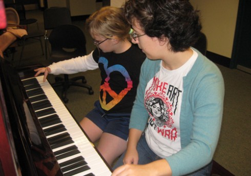 Emily Troll '10 and a GSAC AfterSchool student play piano together.
