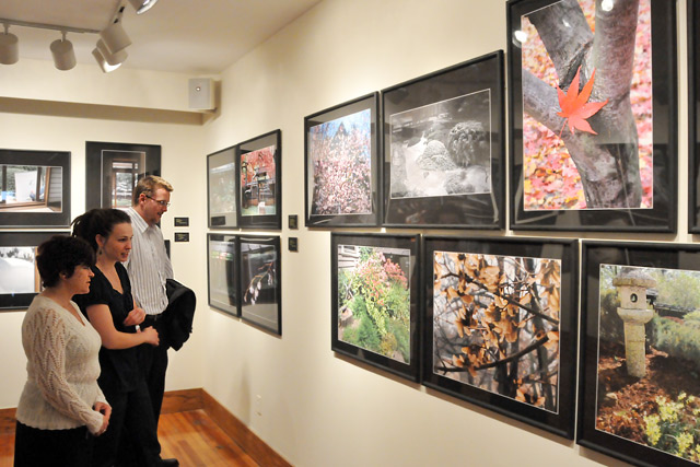 From left, Lisa Calhoun, administrative assistant in the East Asian Studies Program; Brandi Cahill, assistant director of university events and scheduling; and Patrick Dougherty, development researcher/writer; admire photos in the exhibit. Curator Dowdey included images of the garden captured in every season. 