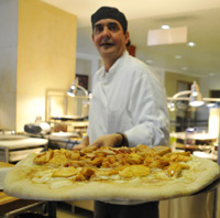 "The Pizza Man" Mert Champagne shows off a cream cheese and apple pizza, fresh from the oven. 