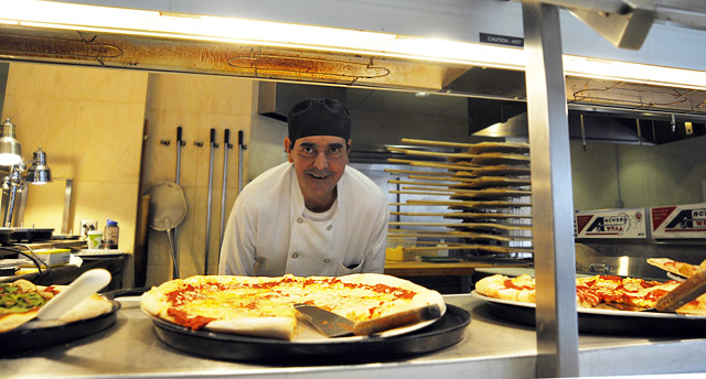 Mert Champagne, a cook in Usdan University Center's Marketplace, takes special requests at the pizza station. His specialty is a white pizza made with garlic, ricotta cheese, plum tomatoes, mozzarella and basil. (Photos by Olivia Bartlett Drake)
