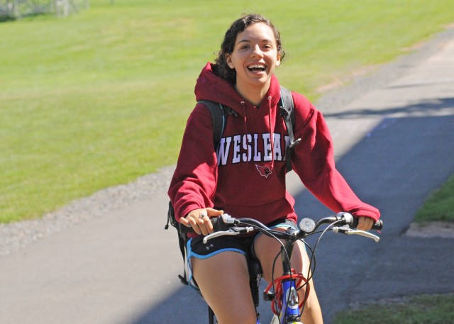 Sporting a Wesleyan hoodie, Rebecca Sokol '15 bikes through campus on Sept. 11. 