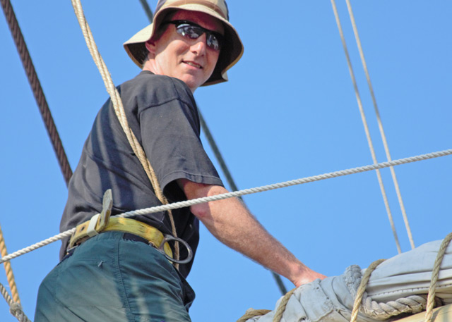 William "Vijay" Pinch, professor of history, adjusts the topsail of the Joseph Conrad, during an NEH-funded summertime institute in June. Pinch participated in the five-week institute, in part, to refine and improve his maritime world history course. (Photo by Heather Agostini)