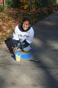 Tracy Mehr-Muska, University Protestant Chaplain, paints a paw at the school.