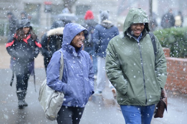Simone Greene '13 and Isaiah Sypher '13 walk near the Public Affairs Center during the afternoon snowfall. 