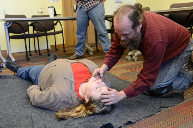 Trainee Charles Carroll, assistant technical director and scenery specialist, practices a head-tilt, chin-lift to open the airway. 