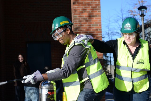 C-CERT trainees Frantz Williams, director of parent relations, and Kathleen Roberts, residential operations coordinator, use the "buddy system" to suppress a fire. 