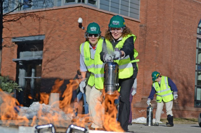 Sherri Condon, accounting specialist, and Mark Grabulis, ITS events temporary employee, learn to use a fire extinguisher at C-CERT training. 