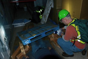 Vinnie Agosta, desktop support specialist, uses leveraging and cribbing to remove a trapped victim during C-CERT training. 