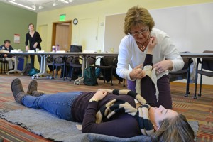 Kris McQueeny, administrative assistant for the Theater Department, practices how to stop bleeding and apply a bandage during C-CERT training. 