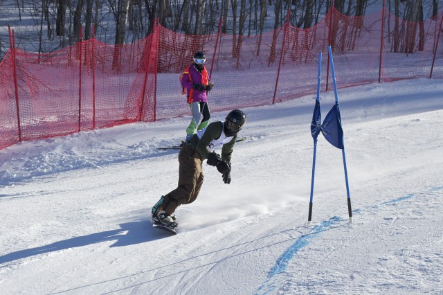 Dylan Penn ’15 leans into the turn of a snowboard Giant Slalom race at the Middlebury College Snow Bowl.
