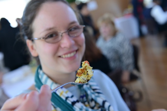 Jen Kleindienst, sustainability coordinator, tries a crab cake bite courtesy of Sheffield's Restaurant at the Crowne Plaza- Cromwell. To promote sustainability on campus, Kleindienst brought her own plate and utensils to the event. 