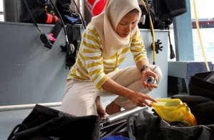 Intan Suci Nurhati '05 prepares equipment for coral drilling. By researching Singapore's corals, she hopes to gain insight into climatic changes in the region. (Photo by Alex Westcott/TODAY)
