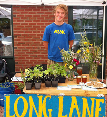 Coady Johnson '15, who is double majoring in astronomy and physics, tends a booth at the North End Farmers' Market, where he sells produce from Wesleyan's Long Lane Organic Farm. Johnson is one of 10 student farmers working at Long Lane this summer. After graduating, Johnson hopes to study astrophysics and ultimately become an astronaut.