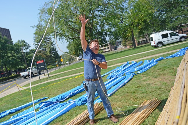 Journeyman Carpenter Paul Marin used a rope to hoist the bamboo sections to the sukkah's top. 