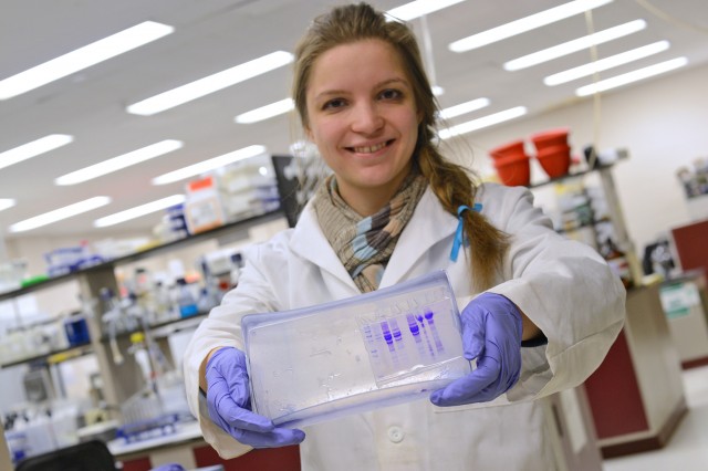 Chemistry graduate student Yoana Gendzhova, pictured here holding protein gels, is a first-year graduate student who is spending her entire spring break working on research with her advisor, Erika Taylor, assistant professor of chemistry, assistant professor of environmental studies.