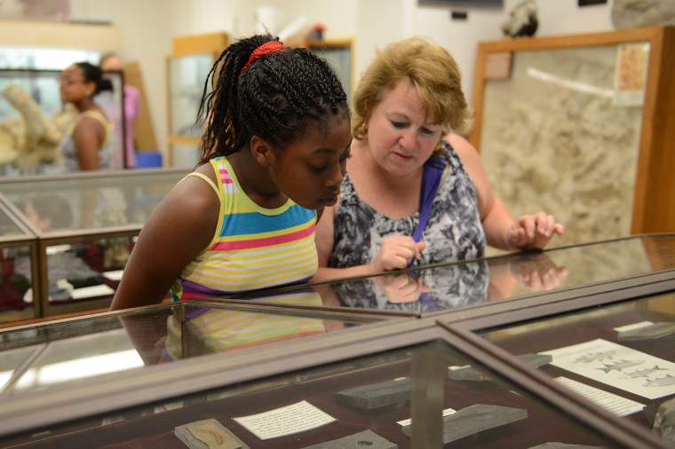 A student and her teacher, Ms. Thompson, look over Connecticut Valley Jurassic Fossils. 