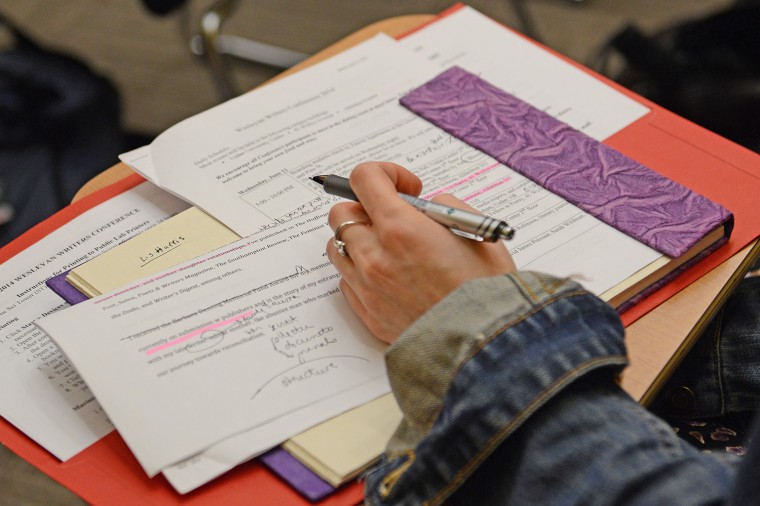 A Writing Conference participant takes notes. 