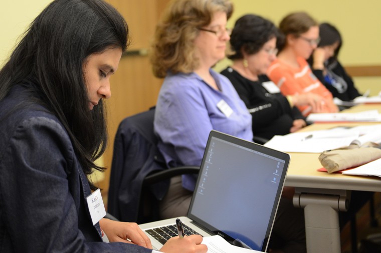 A conference participant takes notes during the poetry session. 
