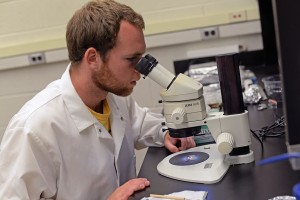 By using a microscope in Wesleyan's Solar Systems Geochemistry Lab, Jack Singer takes a closer look at a Lunar sample.