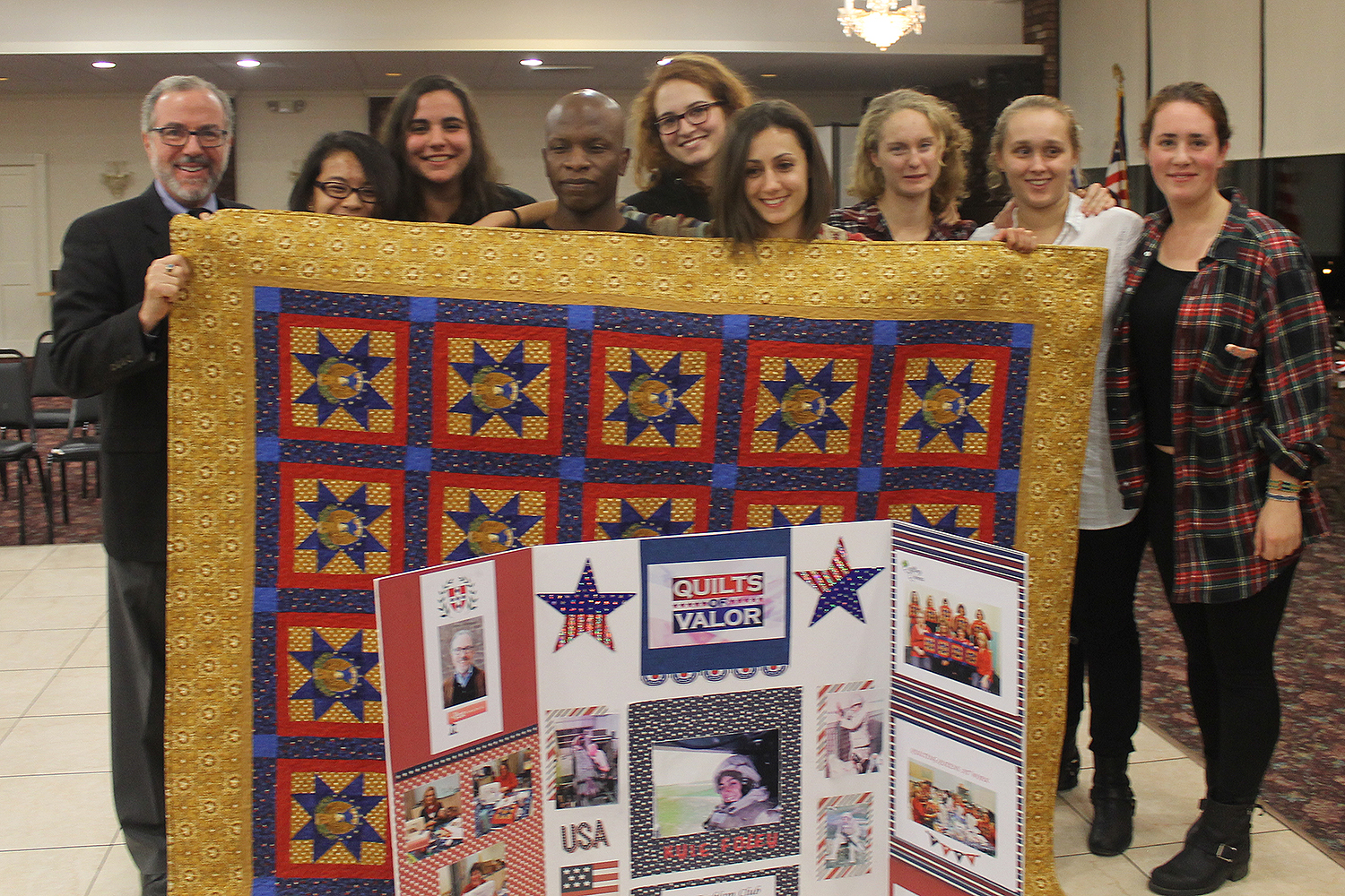Kyle Foley '18 received a Quilt of Valor Dec. 3 at the Emblem Club in Middletown. She's pictured here with several Wesleyan students and at left, Professor Andy Szegedy-Maszak.