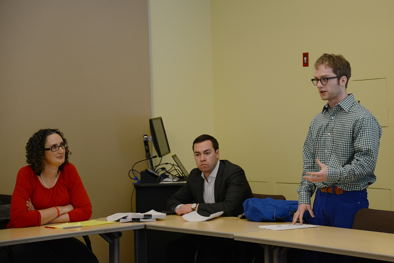 Abigail Hornstein, associate professor of economics and James Hounsell '09 listen to Mattison Asher '17, at right,  who is one of the current leaders of the Wesleyan Investment Group (WIG).