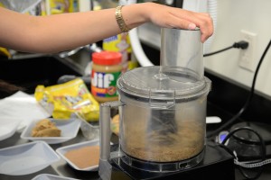 A student prepares the meal mixture in a food processor. 