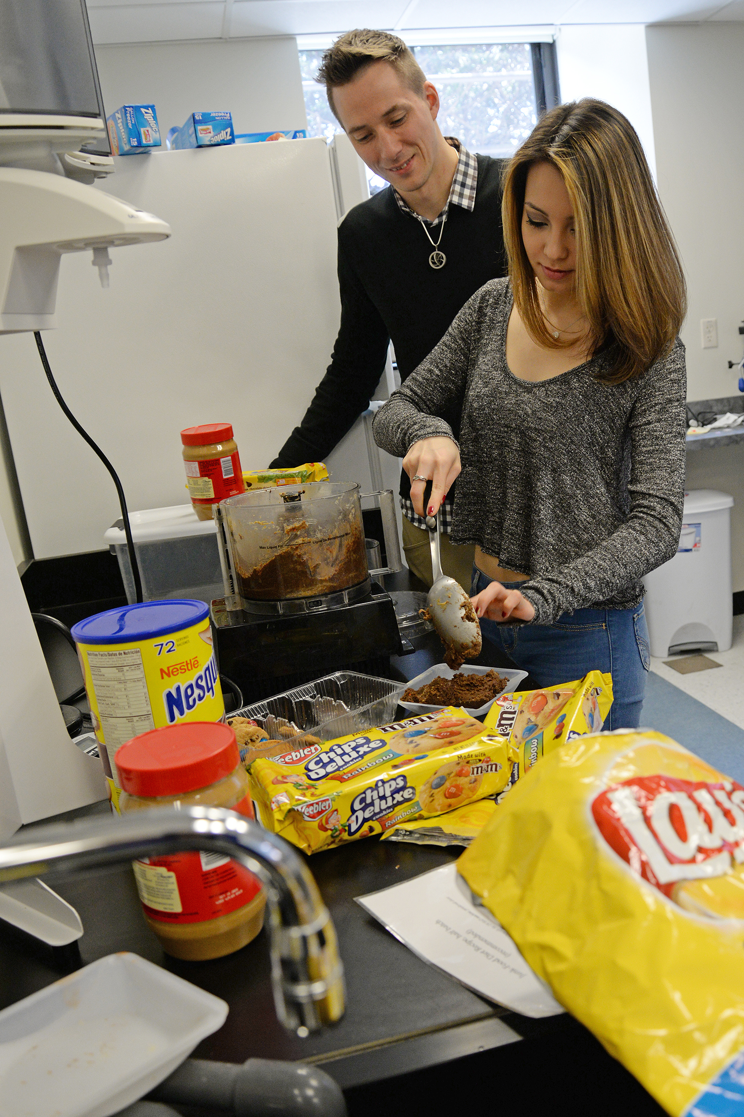 Mike Robinson and Rebecca Tom '16 remove the junk food concoction from the food processor.
