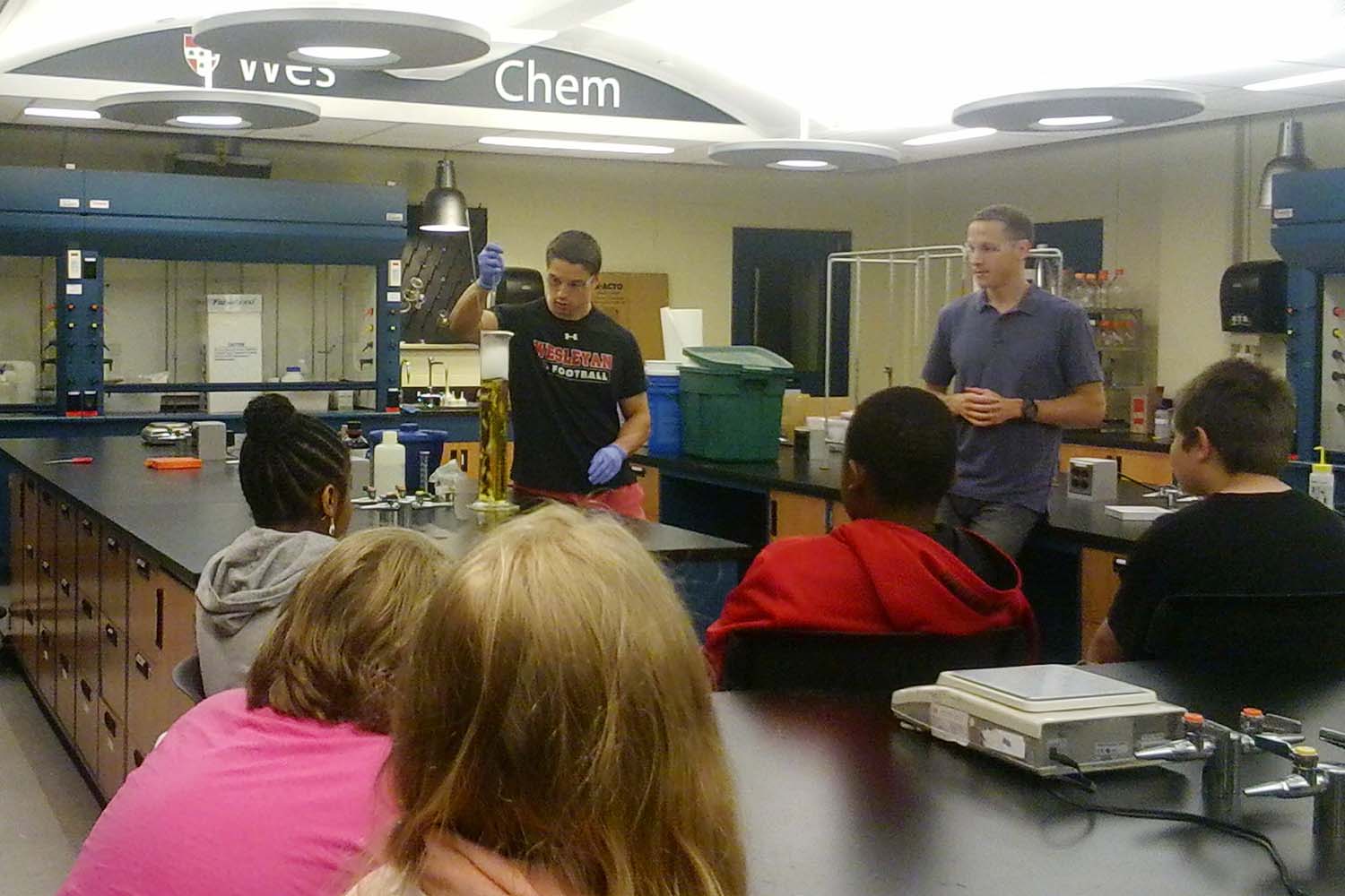 Brian Northrop, assistant professor of chemistry, and Snow School students watch chemistry in action during their visit to Wesleyan. This annual program allows local fifth graders to see how science can be exciting as well as educational.