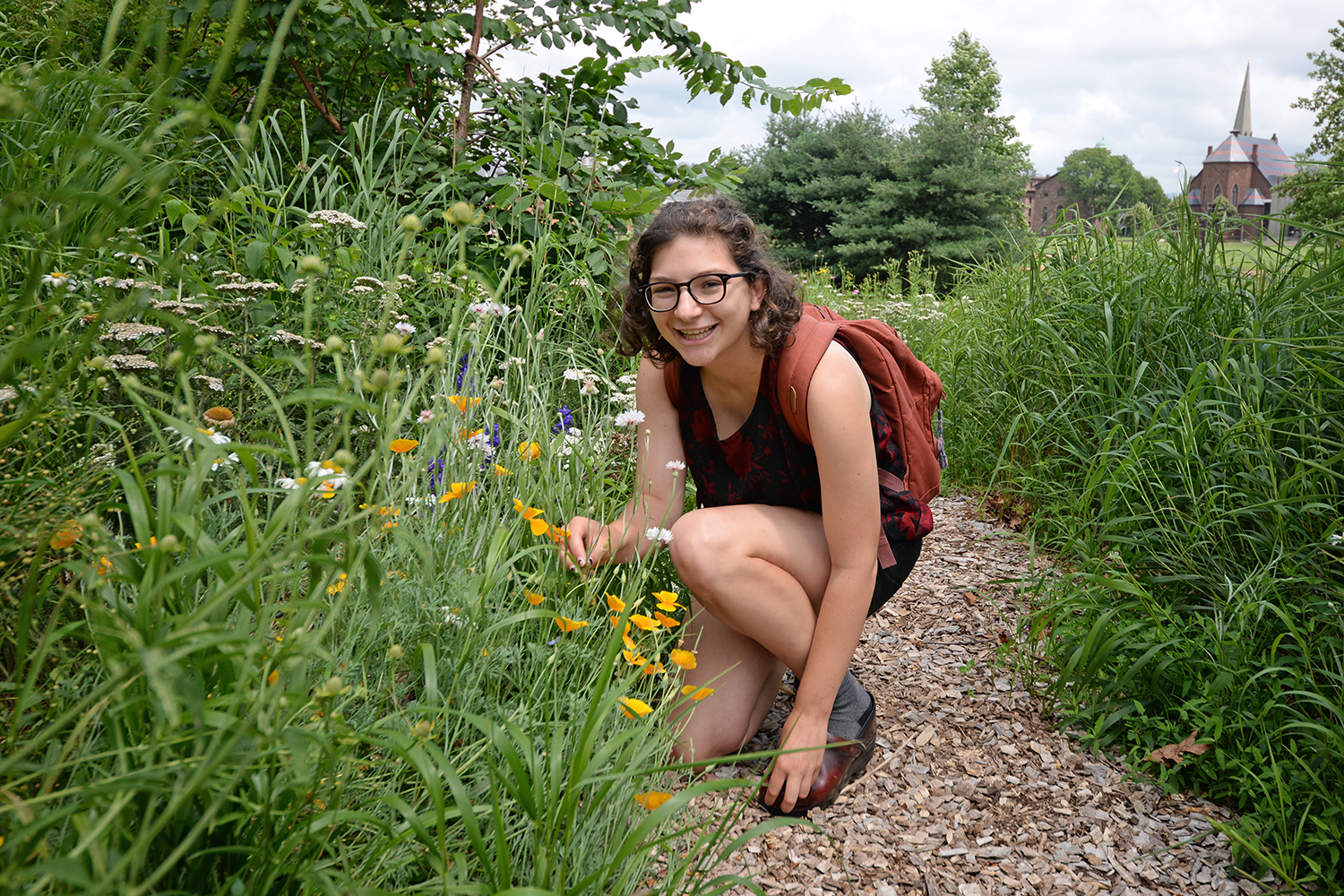 Heather Whittemore ’17, who is working on campus this summer, enjoys occasional strolls through the WestCo. courtyard. “I like to check out what’s blooming,” she said. 