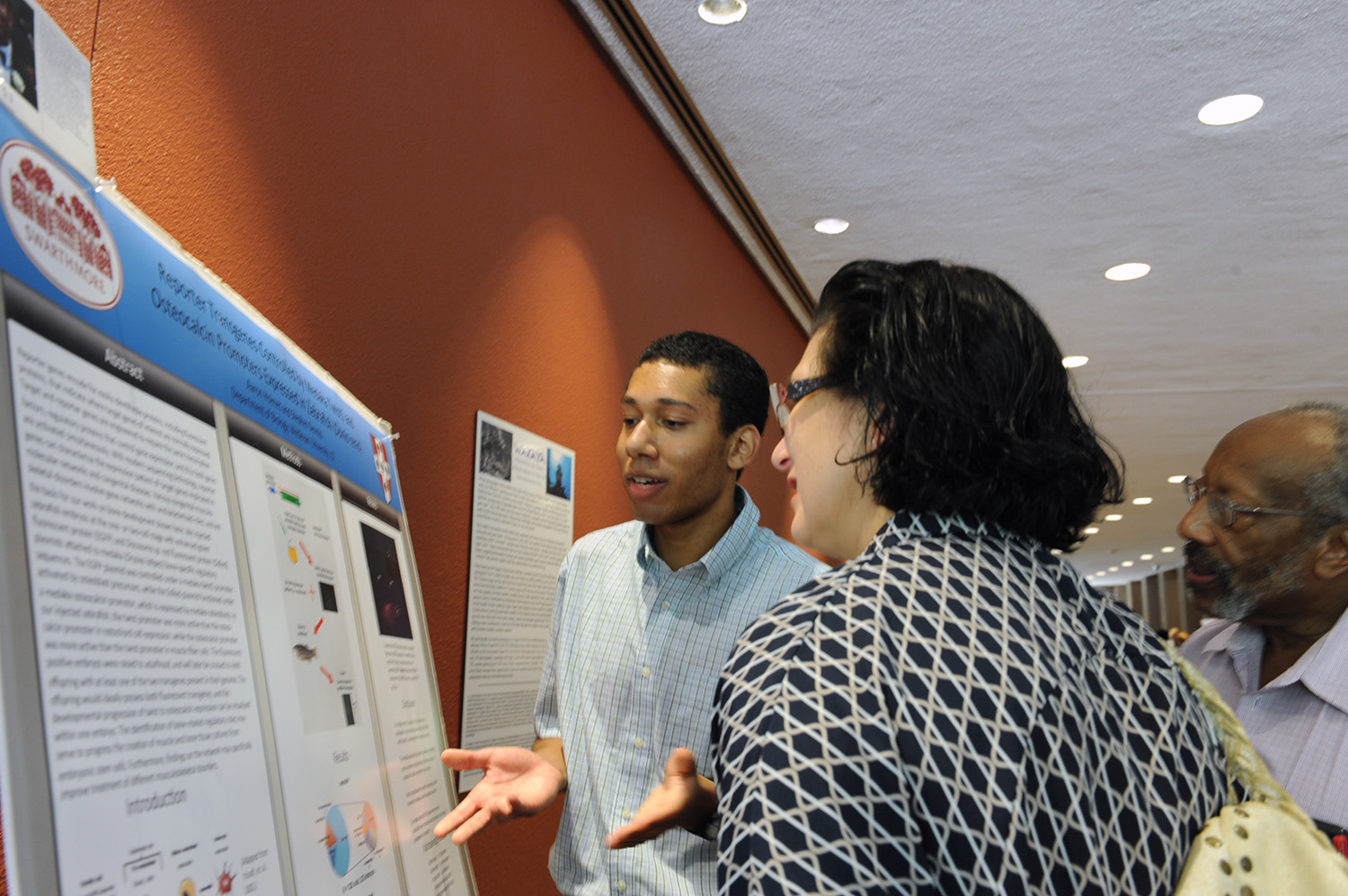 Aaron Holmes ’xx talks to onlookers about his poster, "Reporter Transgenes Controlled by Bone-specific Medaka Promoters Expressed in Zebrafish (Danio rerio)." Holmes' faculty adviser is Stephen Devoto, professor of biology, professor of neuroscience and behavior.