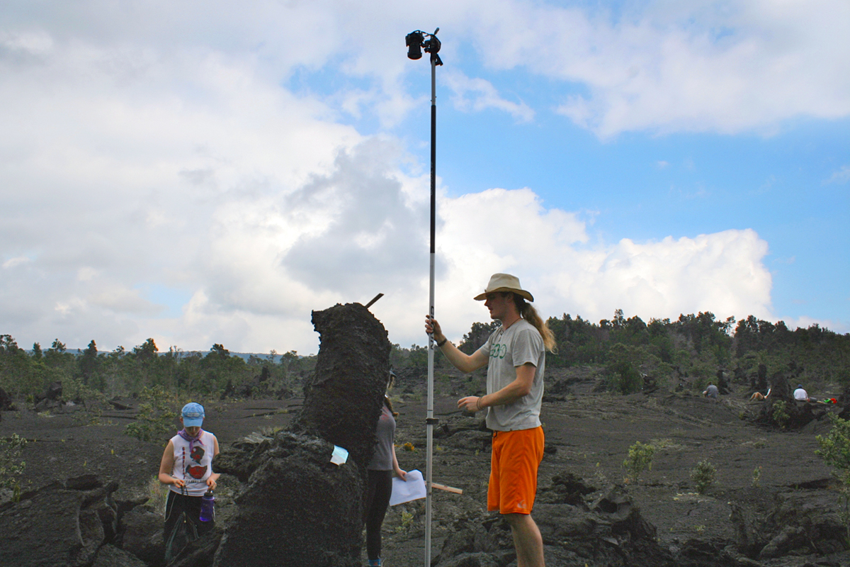 Will Sawyer '16 uses a long “selfie stick” to photograph a top view of lava tree mold on a 1974 lava flow while Dara Mysliwiec '16 and Alex Fireman'16 assist.