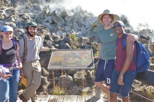 Students gather near the Hawaii National Volcanoes Park sign and sulfur springs.