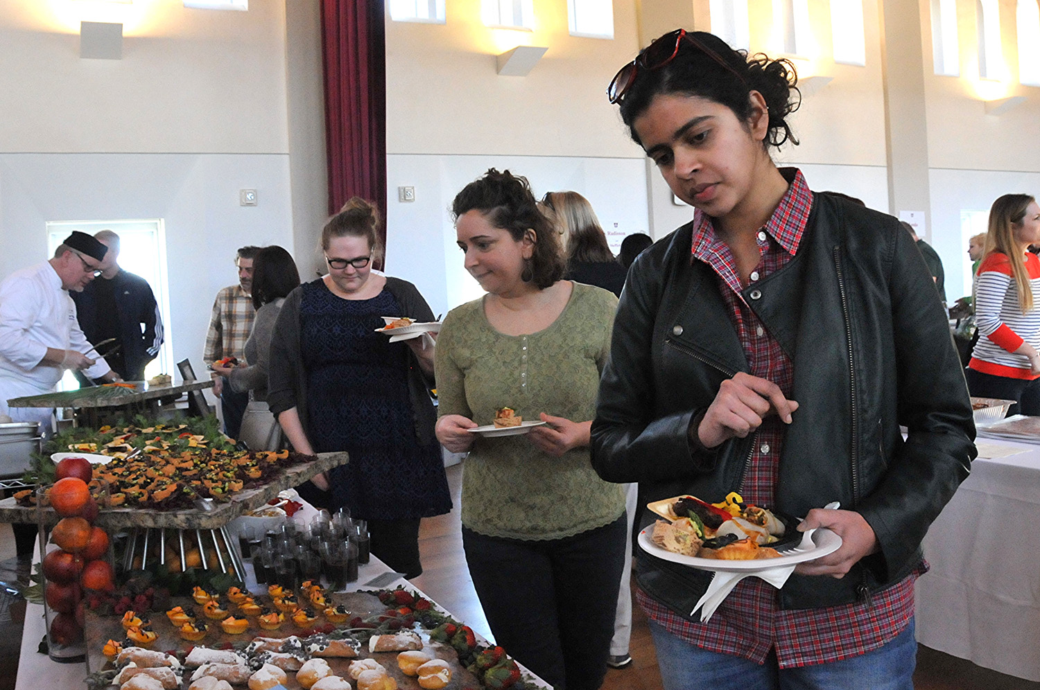 Natasha Kini, assistant director of online communications for University Relations, and others peruse the dessert spread.