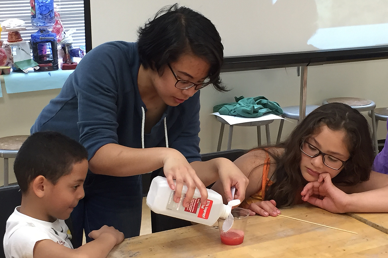 Erin Delon creates an experiment with two GSTLC students. Erin Delon creates an experiment with two GSTLC students. 