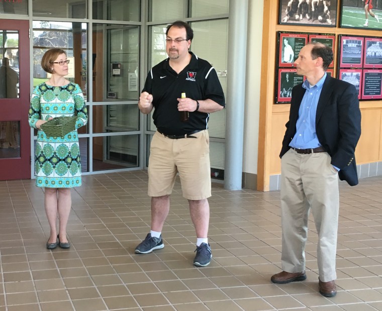 Thayer Talbot, Jeff McDonald, and Wallace Jones stand in the lobby of the Freeman Athletic Center. Jeff McDonald is speaking.