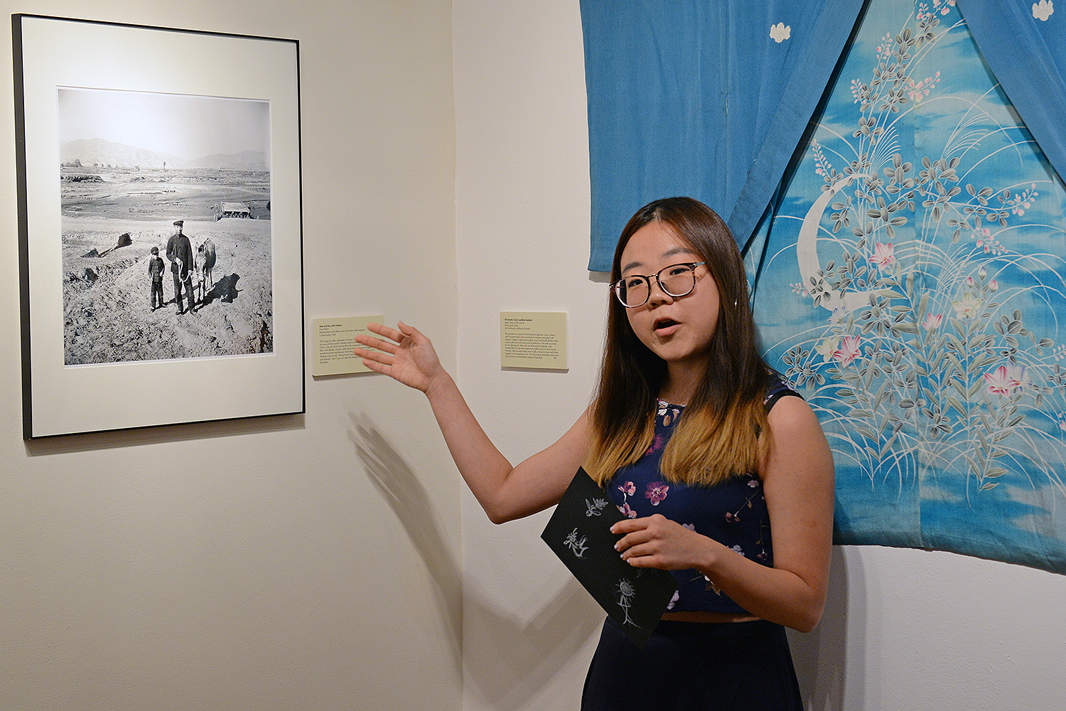 Student curator Lucia Wang ’17 spoke about a photograph titled “Man and Boy with Donkey (2001) by Gay Dillon. The image provides a glimpse of classic Chinese rural society. A man, his son and their family’s donkey stand in the vast landscape of north China. Vast, dry fields are set off by the mountains that rise beyond them. The donkey and the cattle shed in the background suggest the significance of farming and the value of the soil to Chinese rural society. 