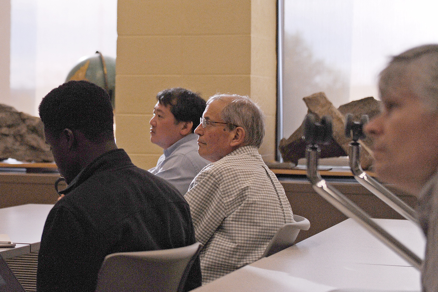 In back, Tim Ku, associate professor of earth and environmental sciences, and Peter Patton, the Alan M. Dachs Professor of Science and professor of earth and environmental sciences, listen to the alumnae's talk. 